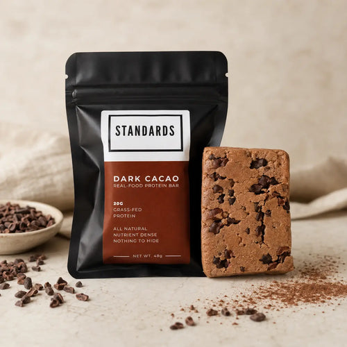 Dark Cacao bar in its pouch with the unwrapped bar and cacao nibs